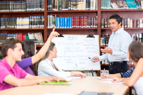 Male teacher explaining the subject to a group of students