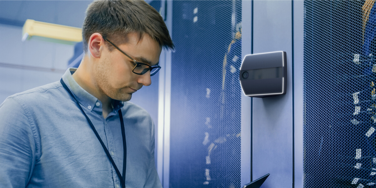 Man in blue shirt using facial biometrics to enter a data center
